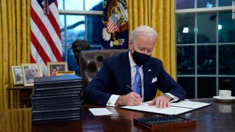 President Joe Biden signs his first executive order in the Oval Office of the White House on Wednesday, Jan. 20, 2021, in Washington.??(AP Photo/Evan Vucci)
