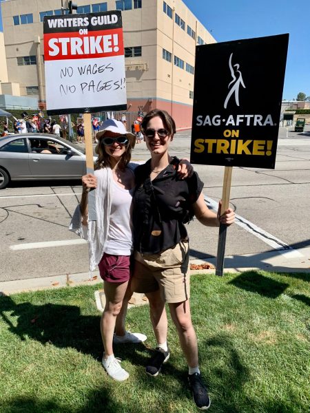 Two writers hold up signs at a strike