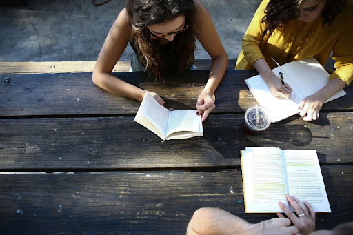 students reading books at a table