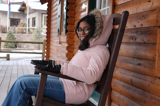 Janvi sits in chair outside of cabin