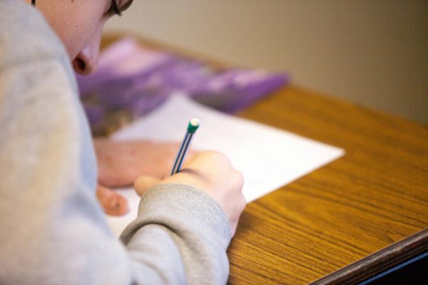 student writes on a paper