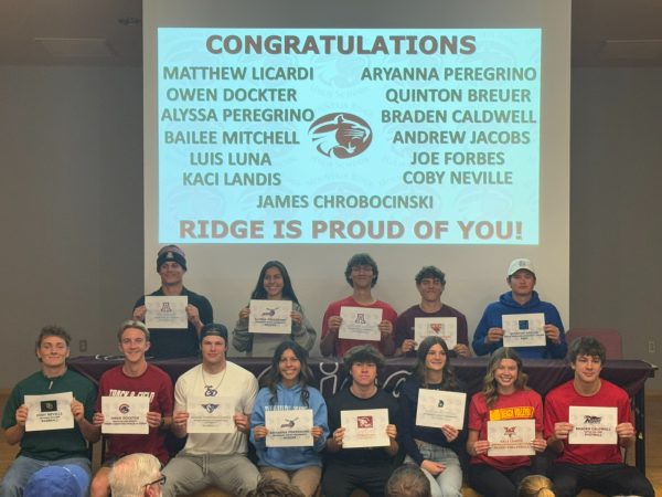 signed athletes hold up papers together