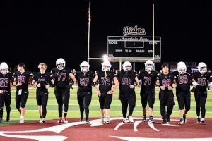seniors walk across field with arms linked