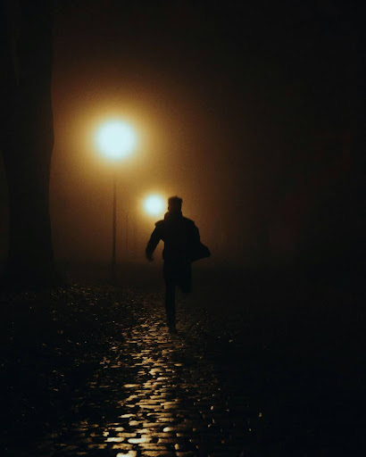 man runs under street lights