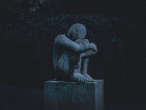 Statue of a person with their head down